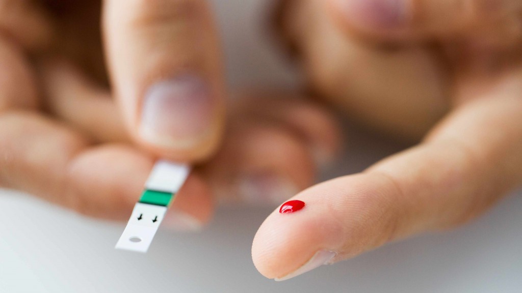 a close up of a male finger with blood drip on diabetic test strip