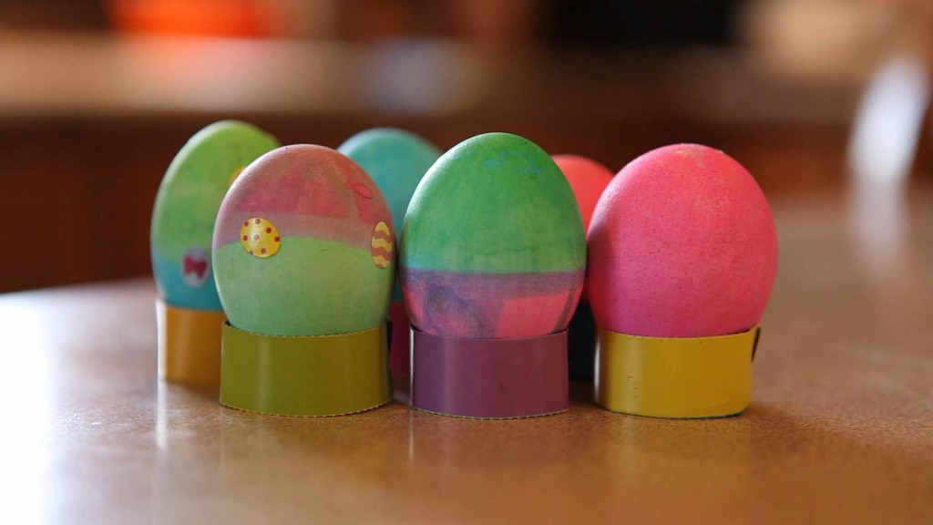 various colored Easter eggs in rows on a table