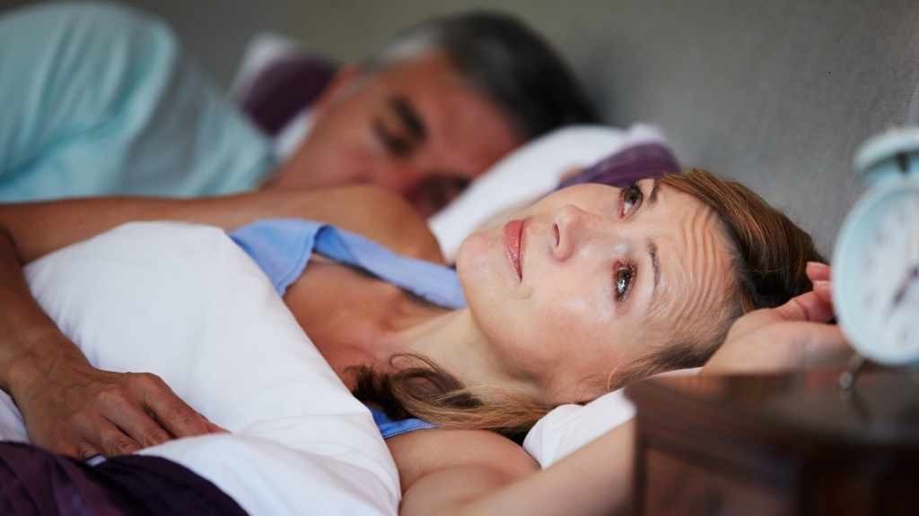 couple in bed with woman suffering from insomnia