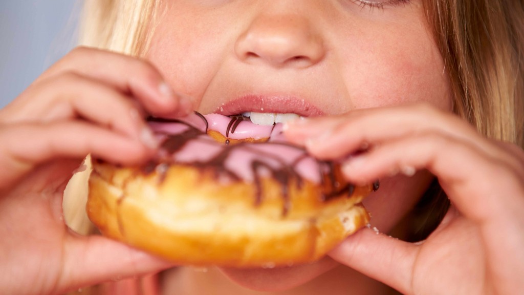 a young girl is eating a donut