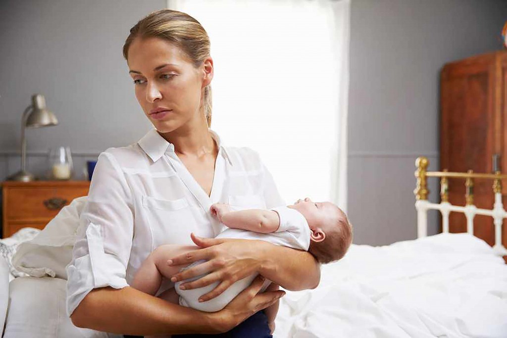 a depressed woman holding an infant baby