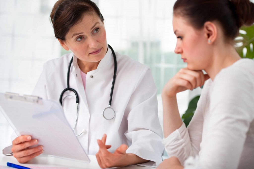 a woman in a doctor's office meeting with physician