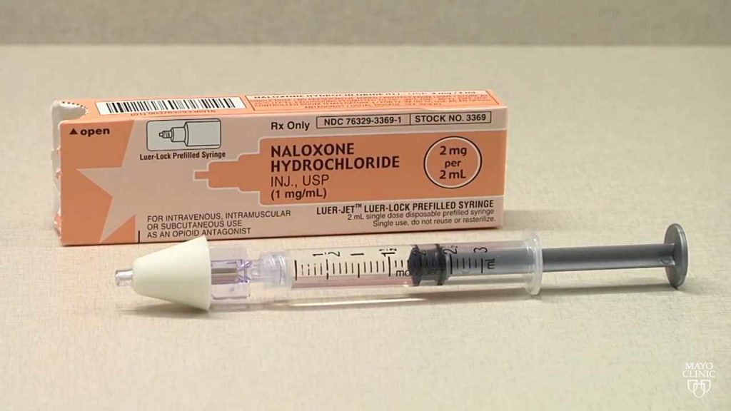 a syringe and box of naloxone opioid antidote