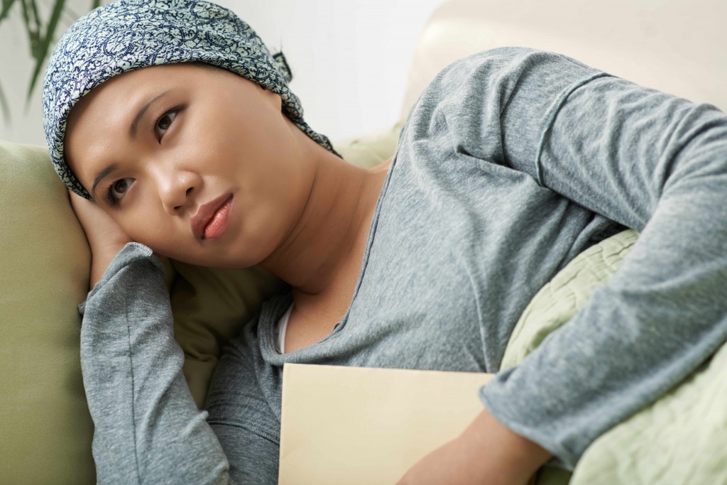 a sad woman with a bandana on her head, maybe a cancer patient after chemotherapy