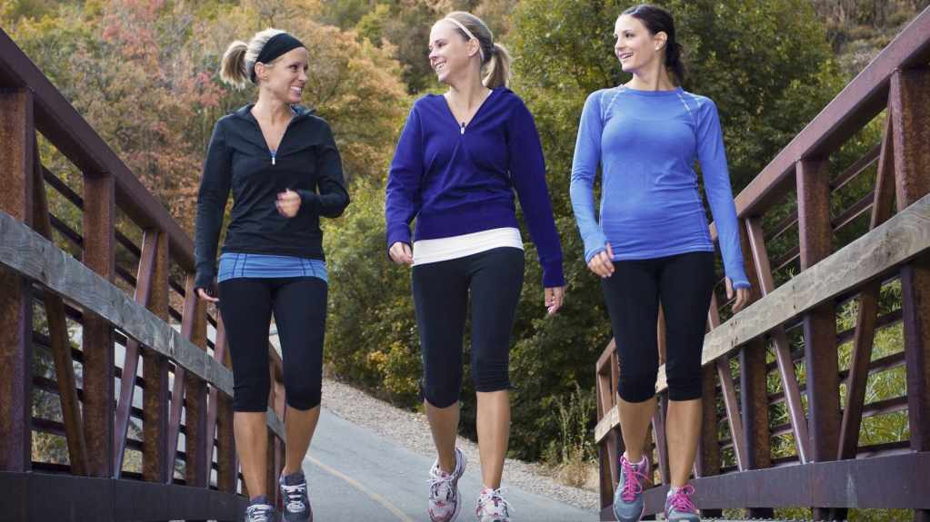 three women walking and exercising together