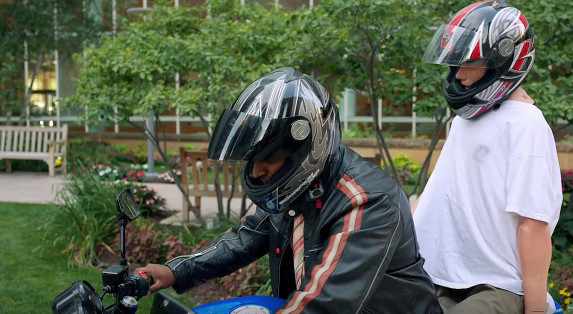 simulation mannequin Gus on a mototcycle with Dr. Pandian wearing helmets