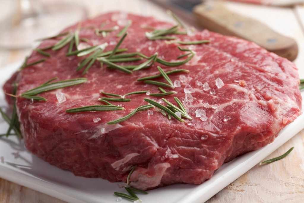 raw beef steak with salt and rosemary