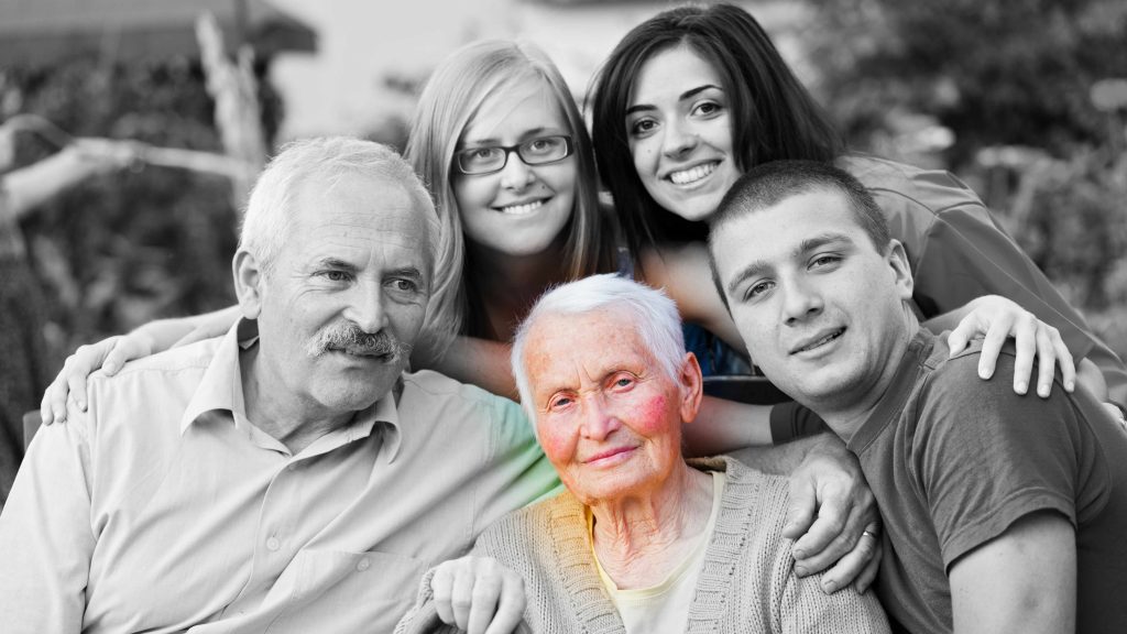 Foto familiar en blanco y negro donde, en color, aparece una anciana con aspecto triste y debilitado por alguna afección o por la enfermedad de Alzheimer