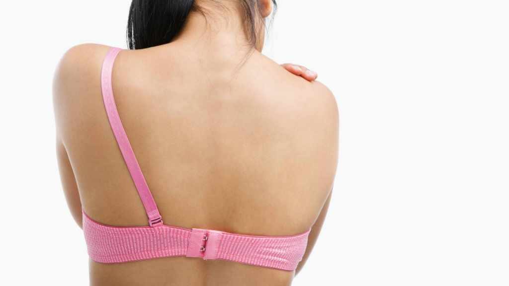 back of a woman in pink bra with one strap removed representing mastectomy