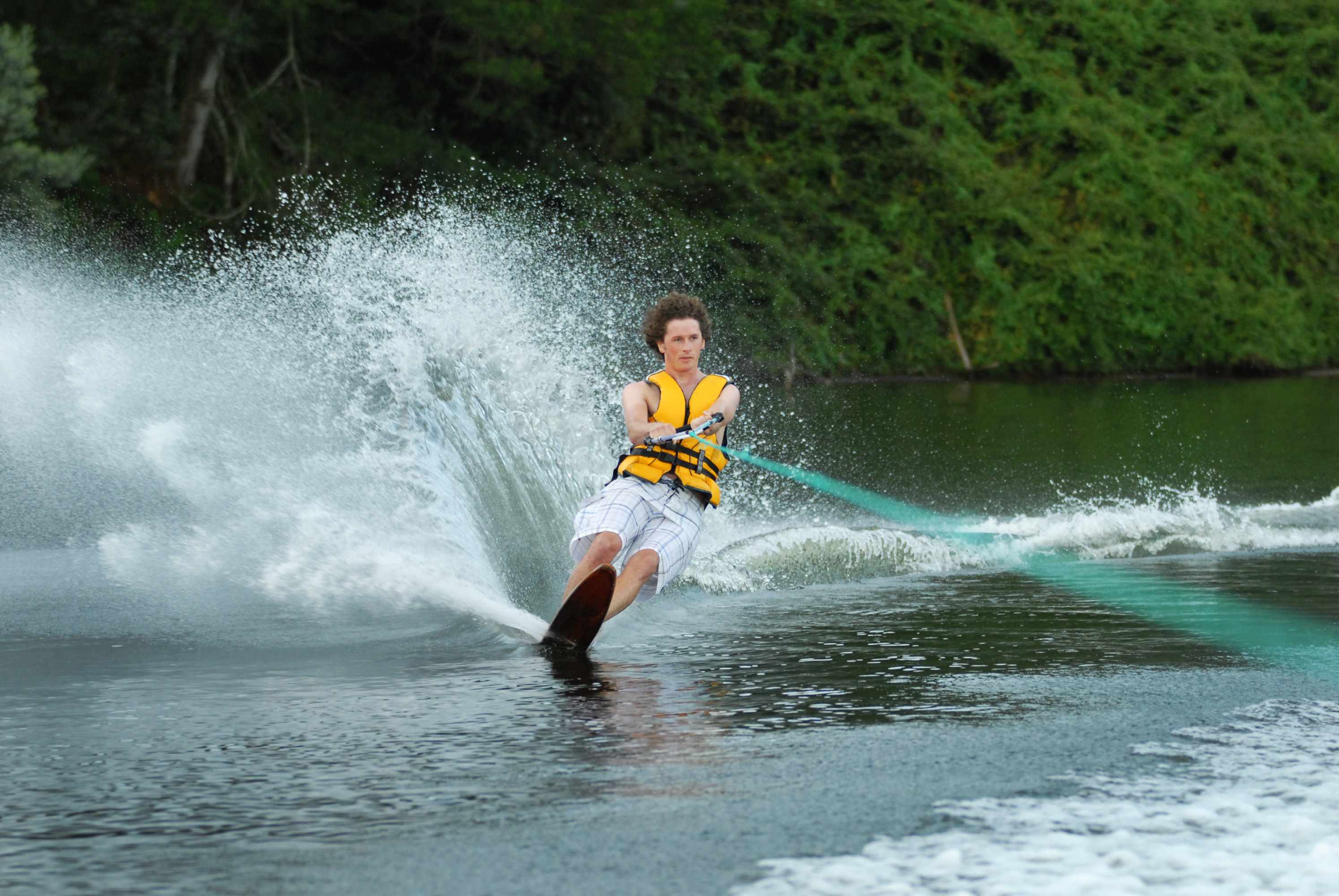 a boy teenager water skiing wearing a life jacket
