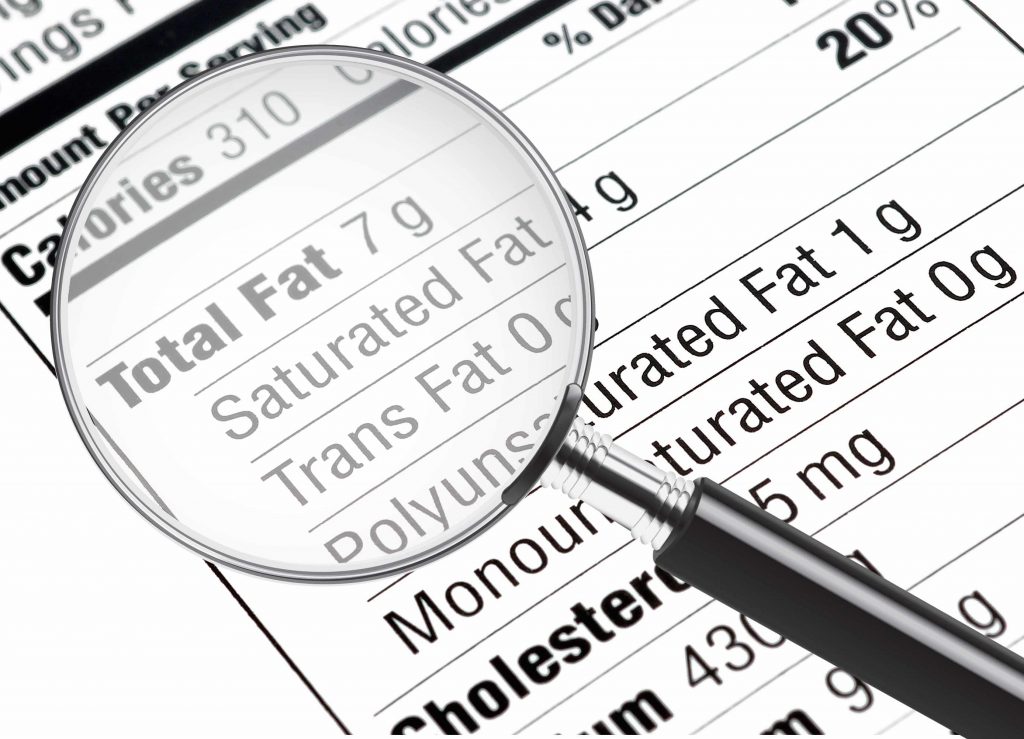 a nutrition information label with a magnifying glass highlighting the fat content, including Trans Fat 0 g