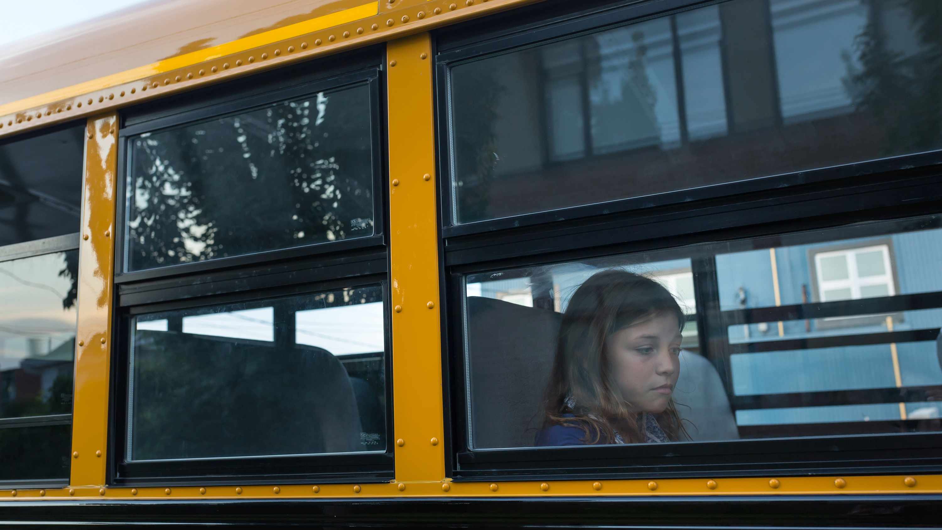 a sad elementary school girl on a bus