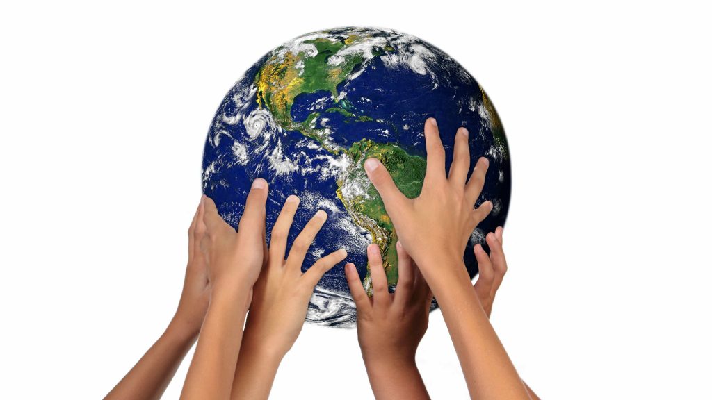 a group of young people's hands holding up the earth, the world, a globe