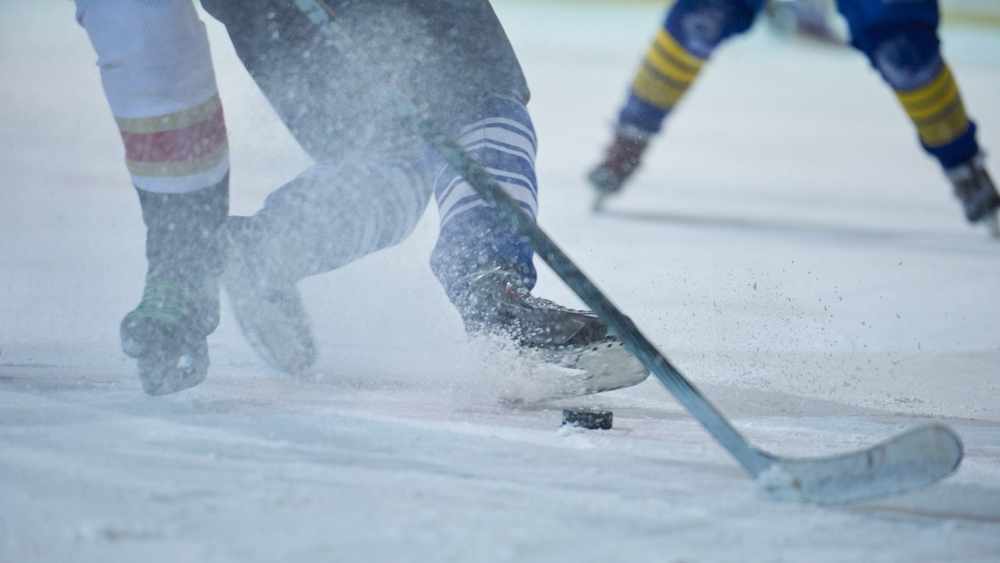 Jugadores de hockey en hielo con los palos y el disco 