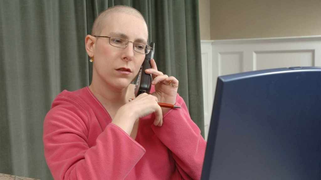 ovarian cancer patient Cindy Weiss on the phone and working at computer