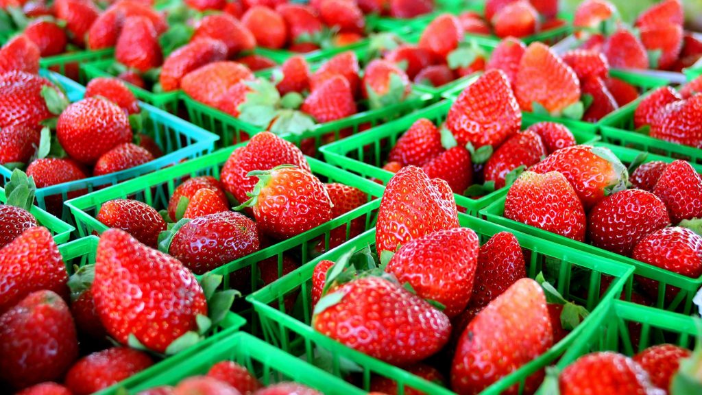 small baskets of strawberries in a fruit market