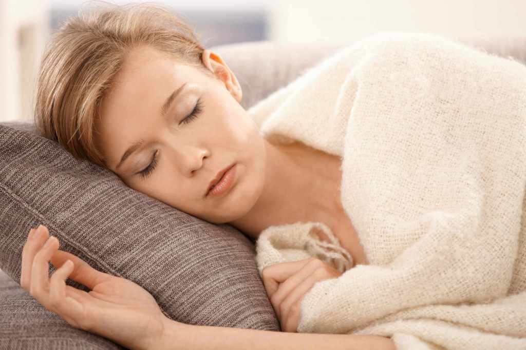 young woman sleeping napping on a a couch