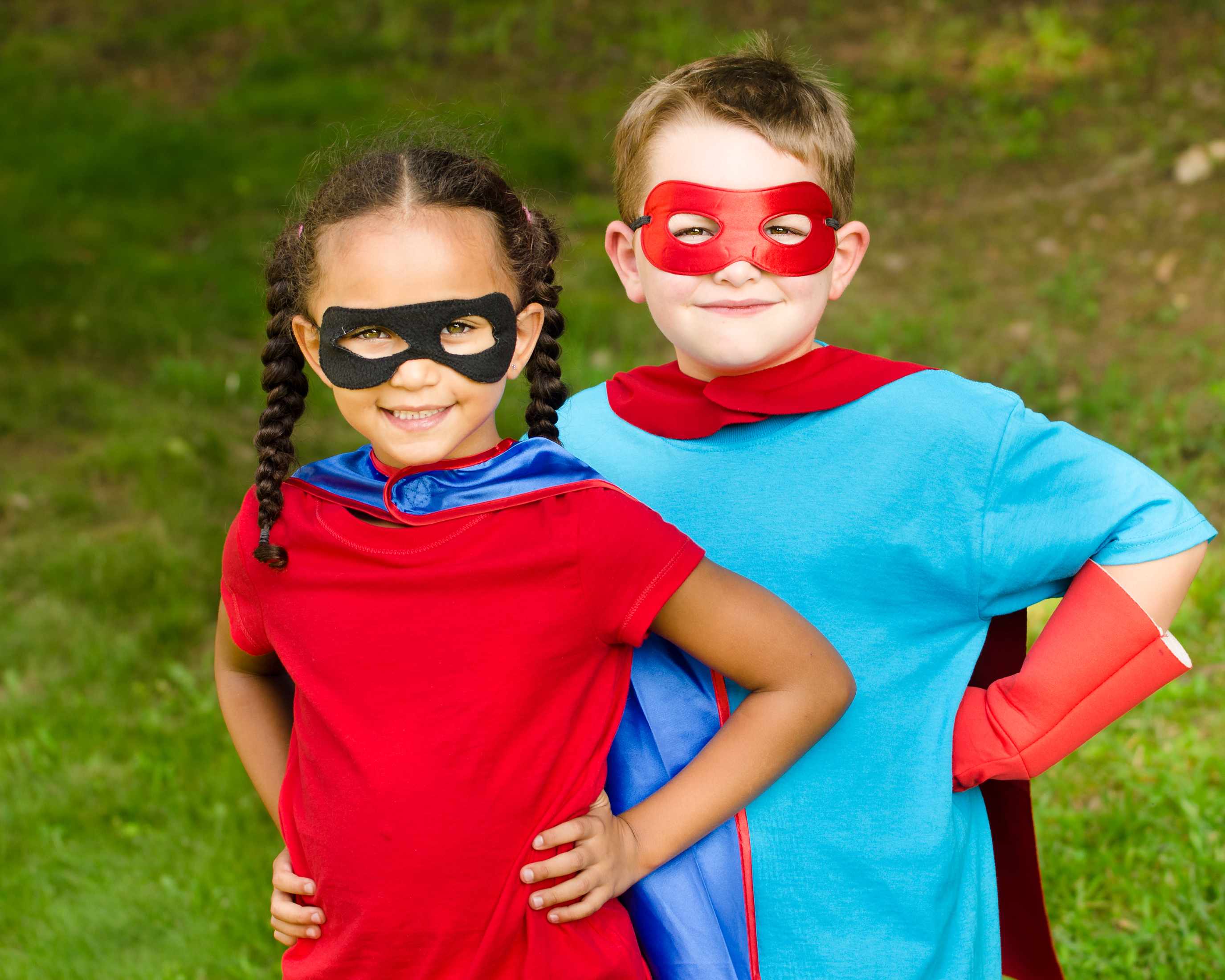 a little girl and a little boy dressed up in costumes as superheroes with masks