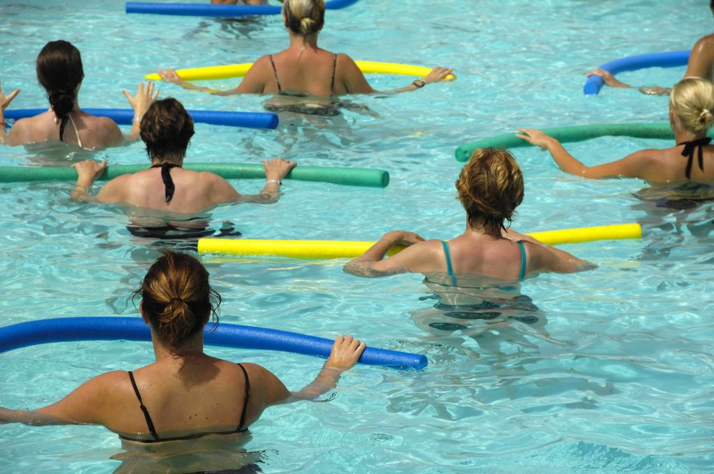 a group of women in a swimming pool exercising and doing water aerobics