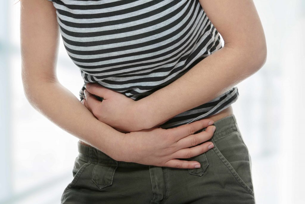 a young woman holding her stomach with pain