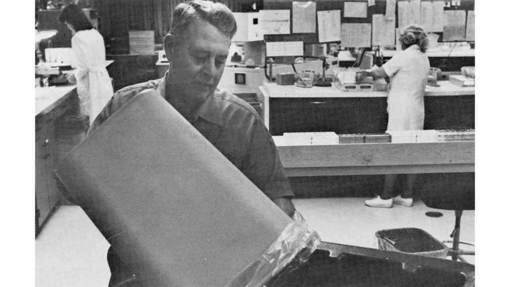 a 1981 photo of custodian Warren Hess working in the Hematology Lab