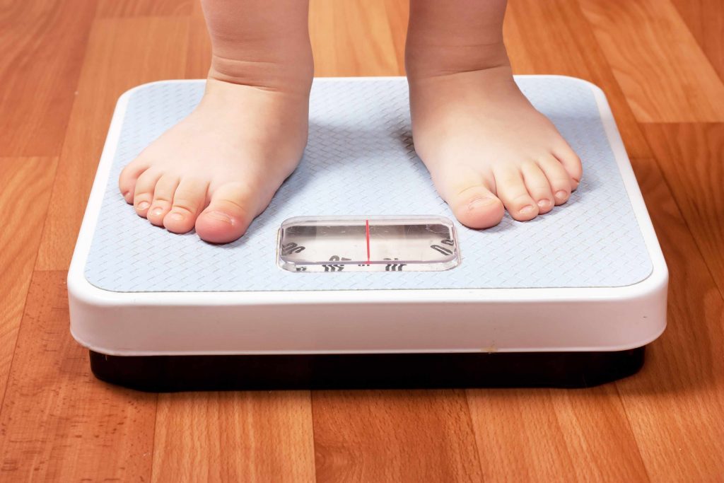 child's feet on a scale obesity