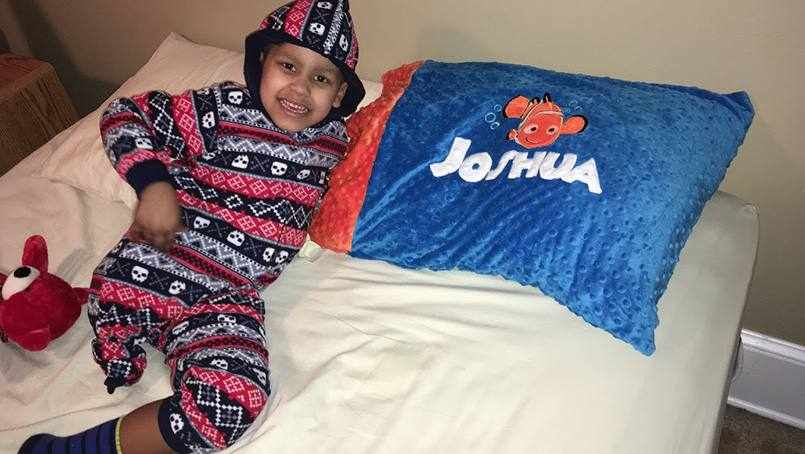 young patient Joshua smiling and resting on his bed