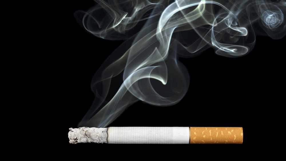 a burning cigarette, with smoke curling upward into the air