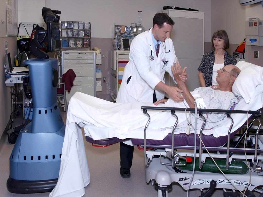 Physician working with patient with telemedicine machine nearby