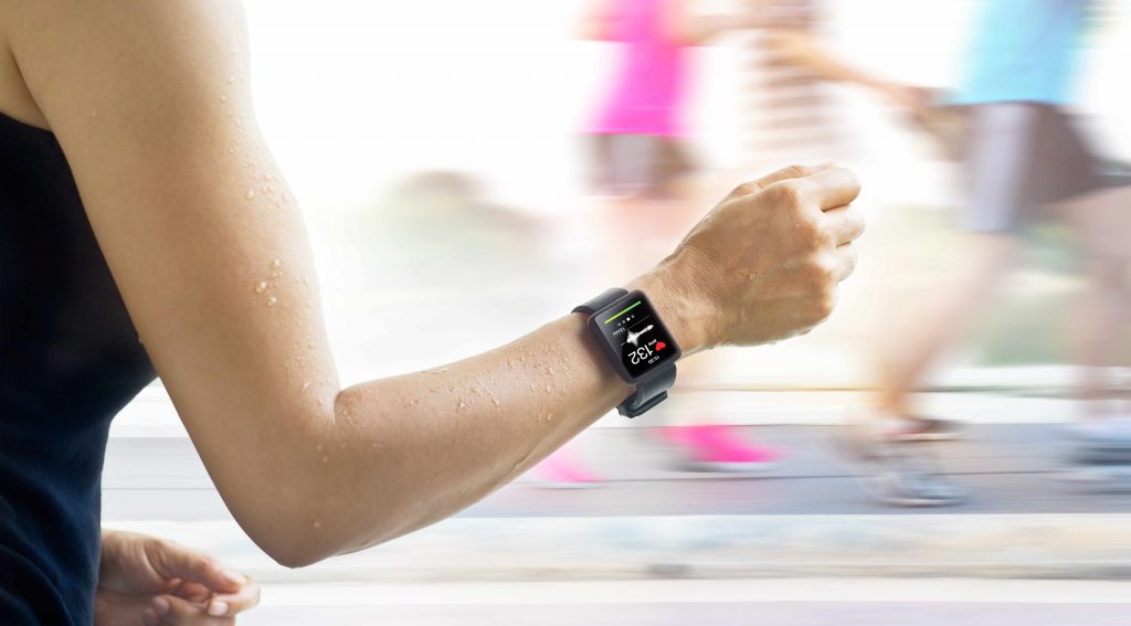 a woman running with an exercise monitor on her arm