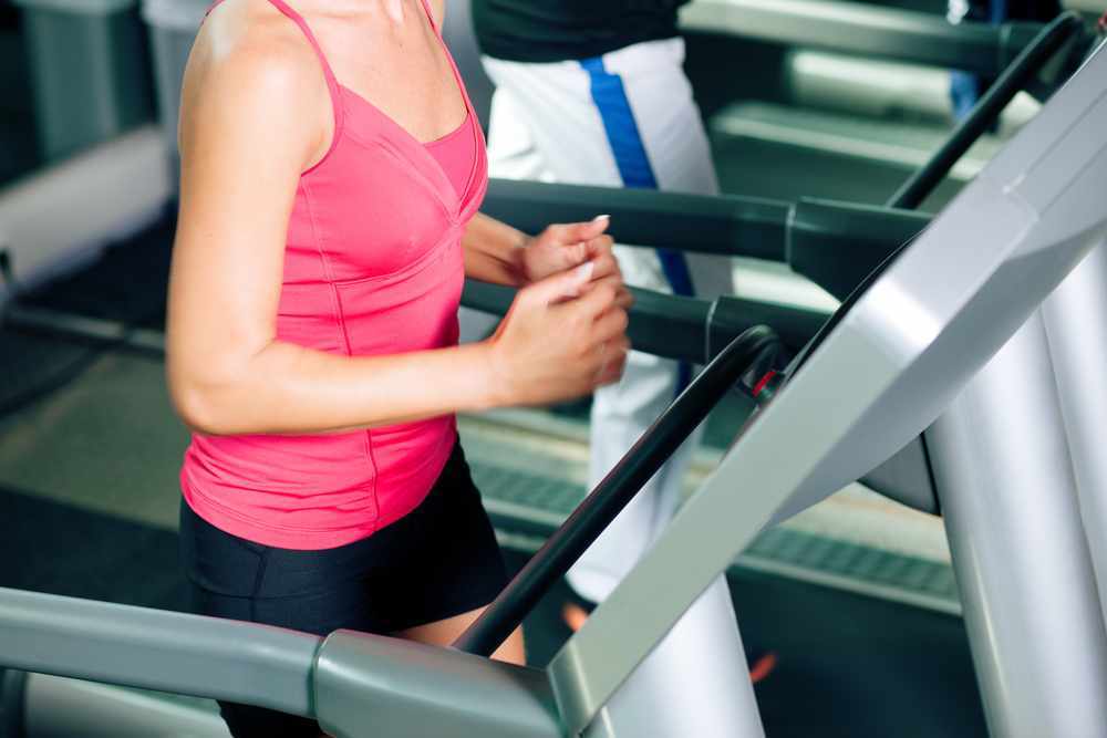 woman in a gym running on a treadmill exercise machine