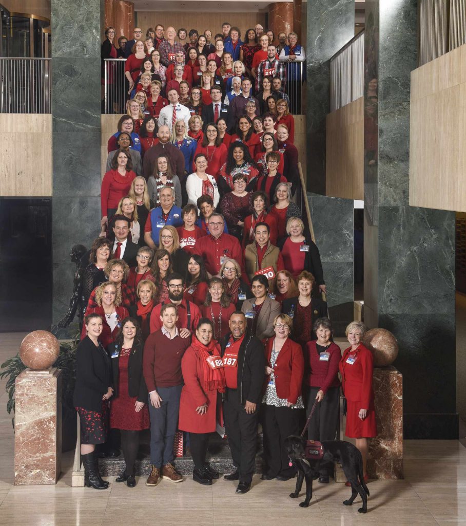 Mayo Clinic employees in red stand on staircase for a photo on National Wear Red Day