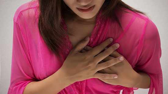 Una mujer joven y delgada con dolor en el pecho por un ataque cardíaco