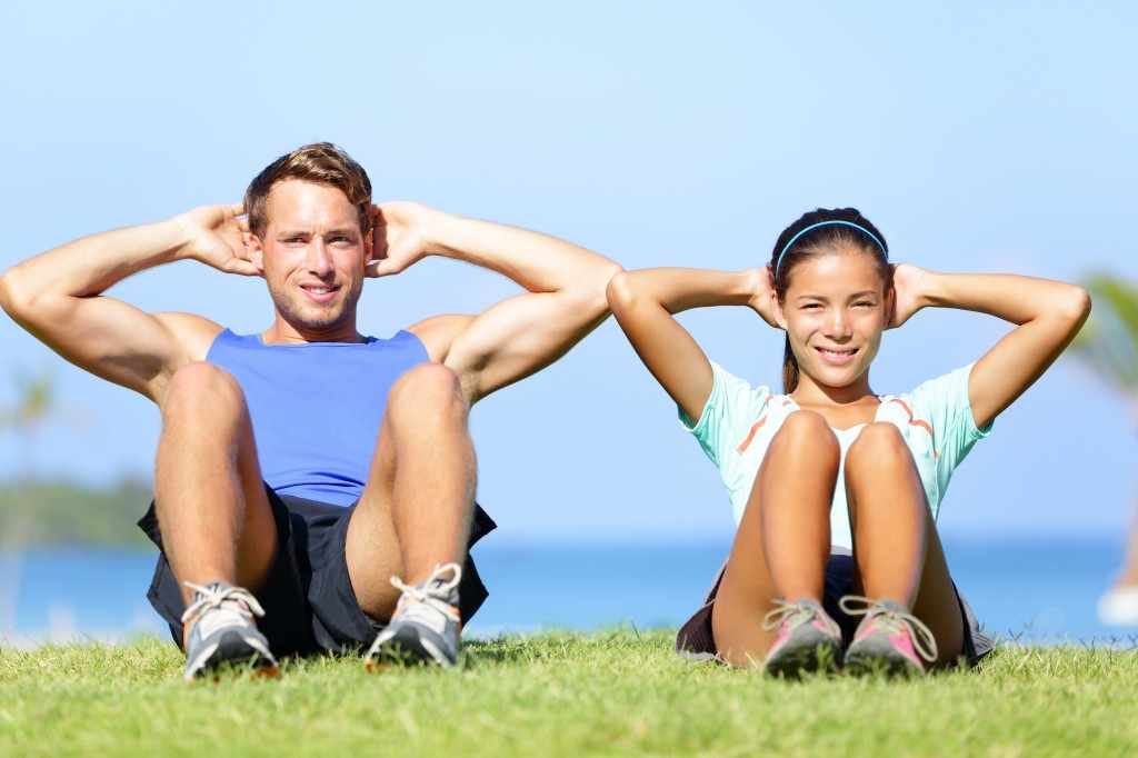 man and woman doing core workout exercises outside