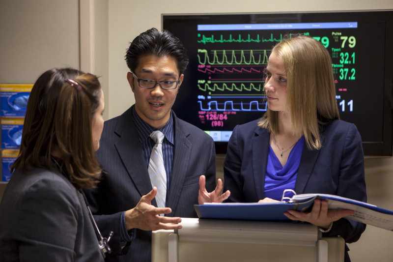 medical students consulting near EKG machine