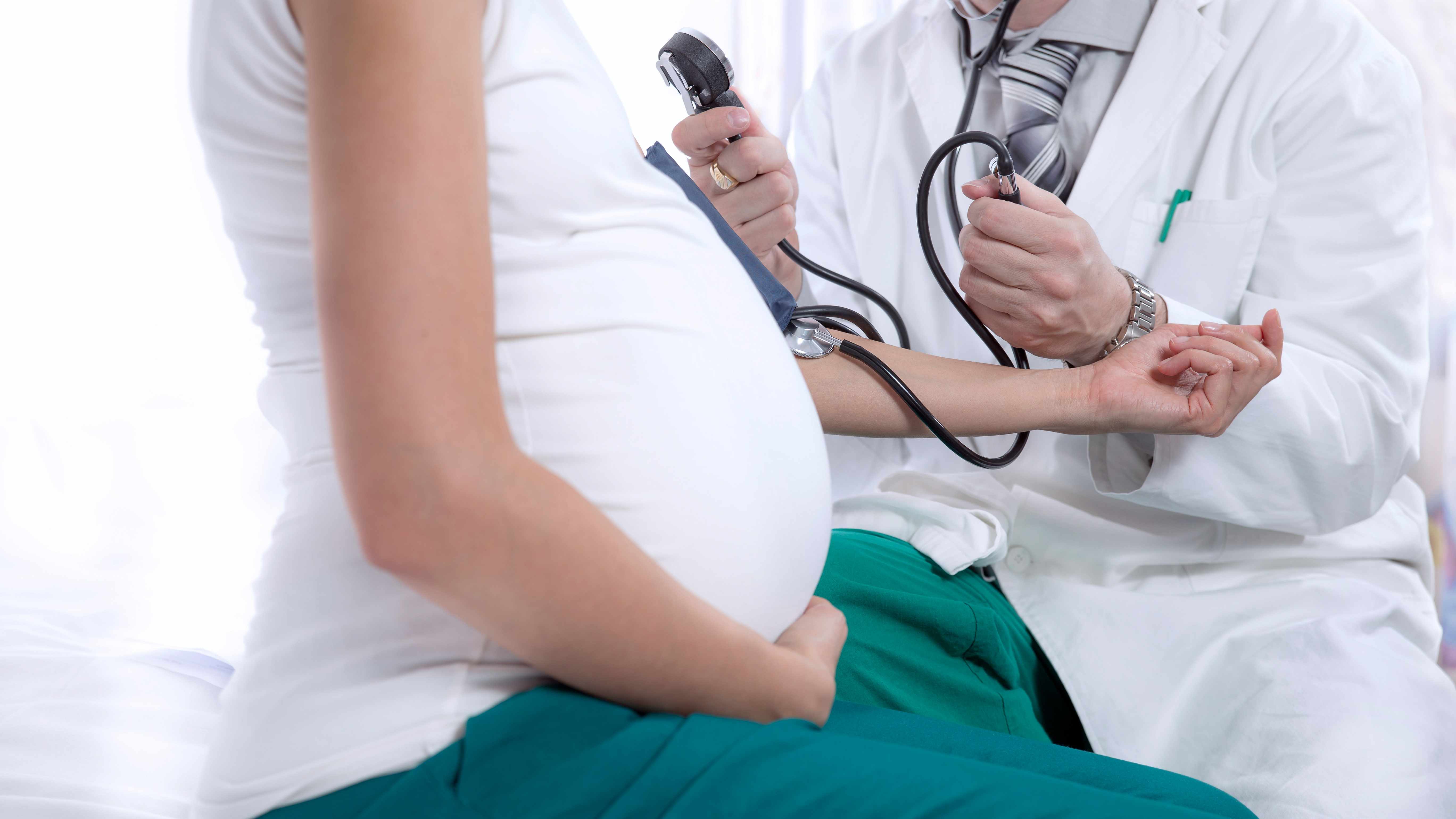 a pregnant woman being check in a doctor's office