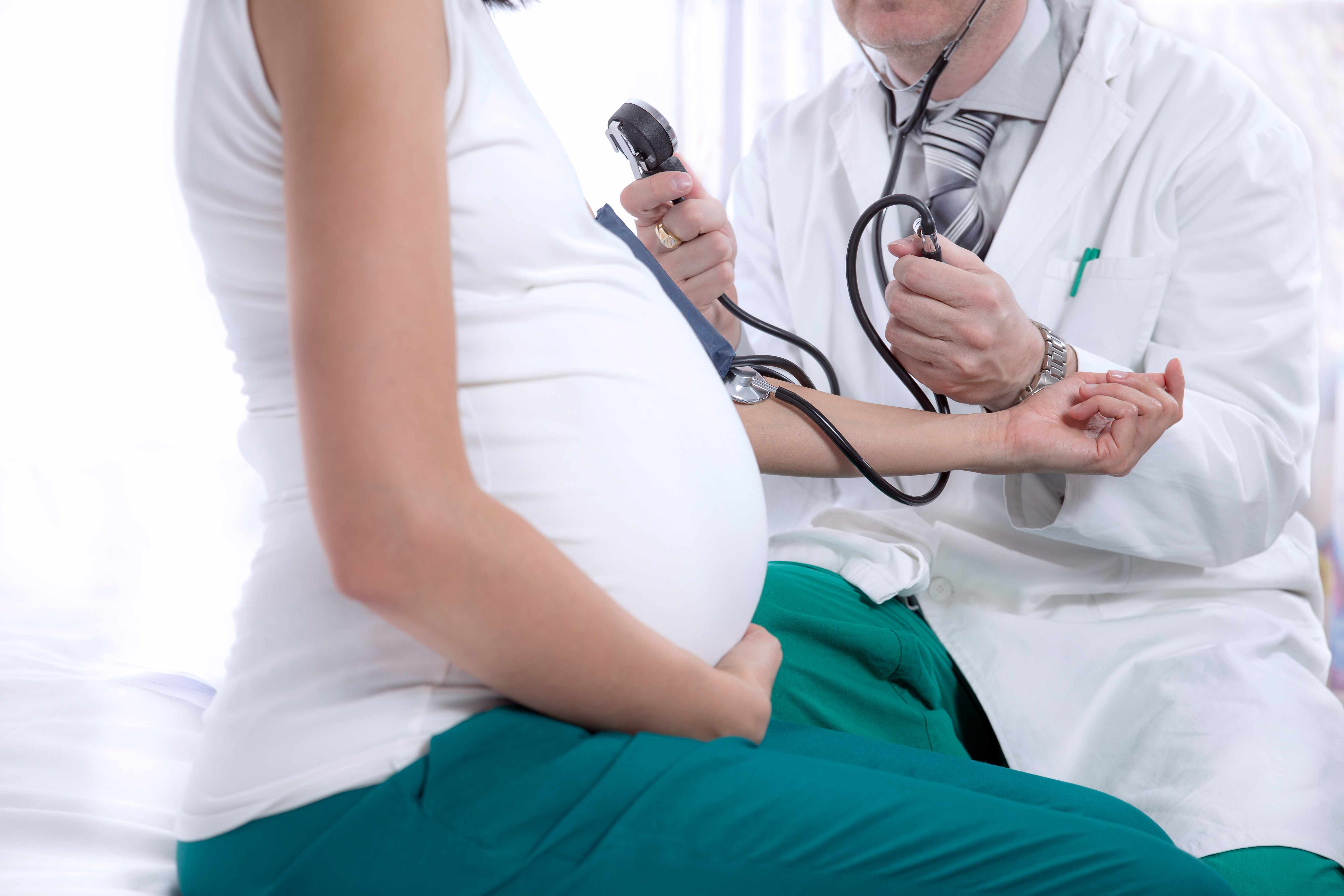a pregnant woman being check in a doctor's office
