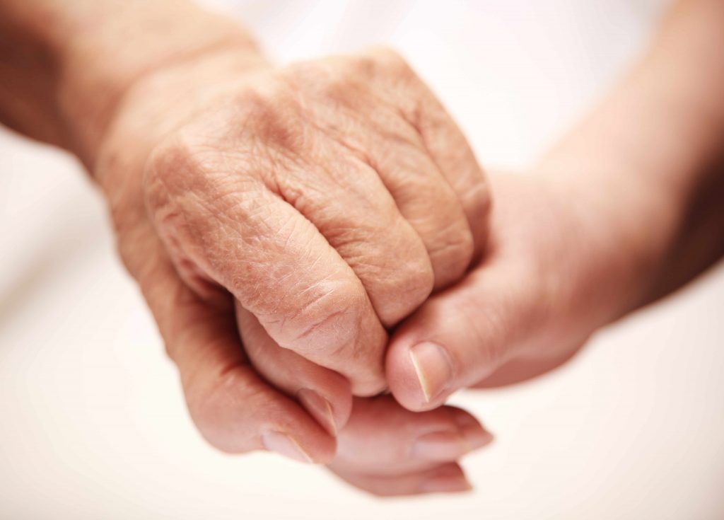 a close-up of two hands clasped, one older and one younger