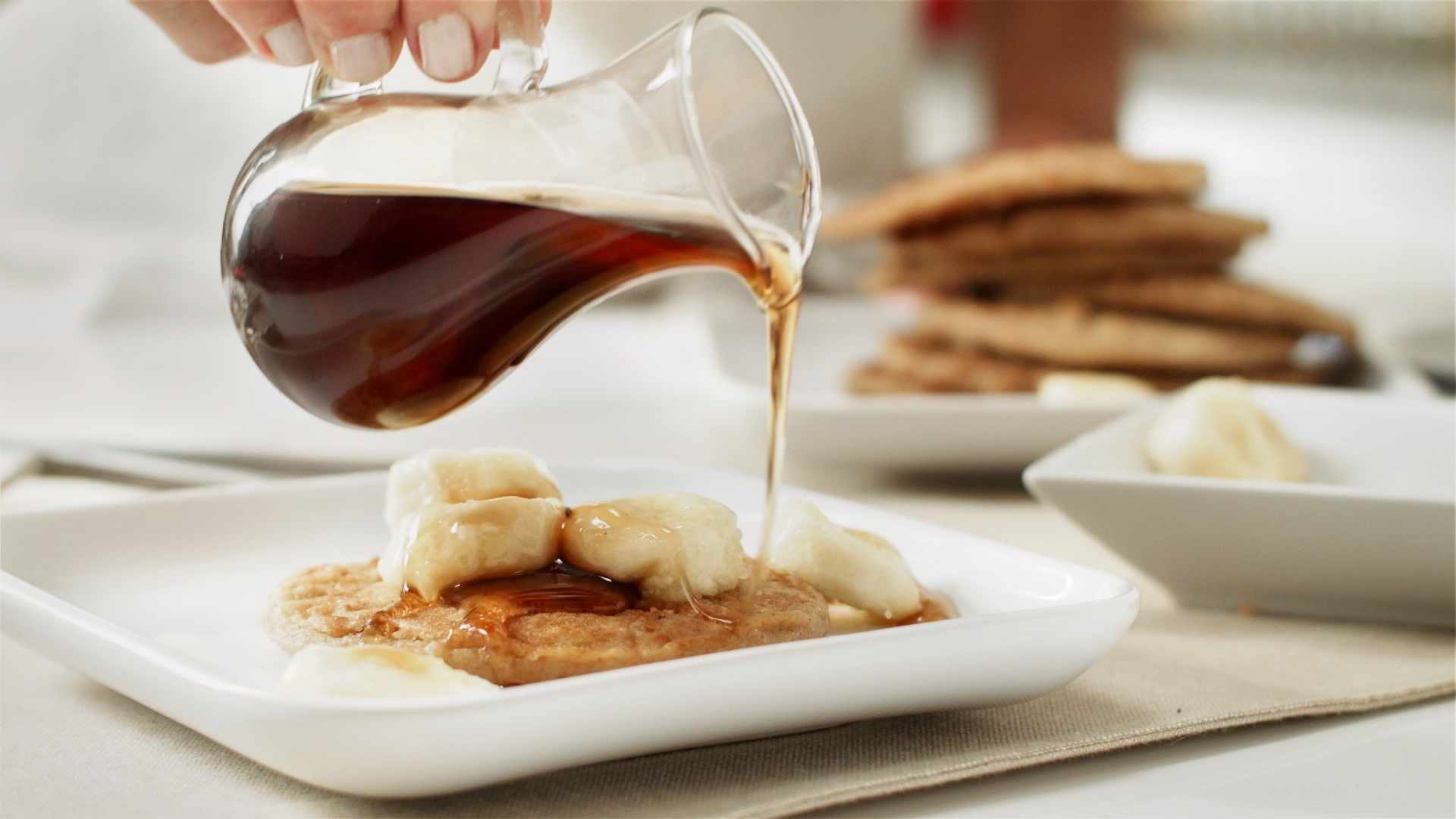 syrup being poured on pancakes