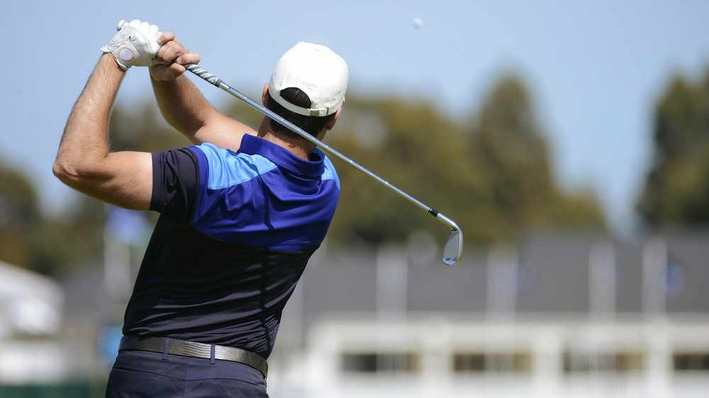a golfer swinging and hitting a golf ball