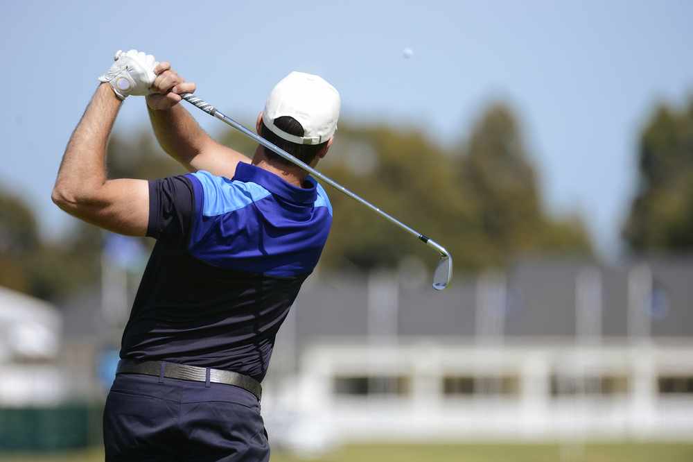 a golfer swinging and hitting a golf ball
