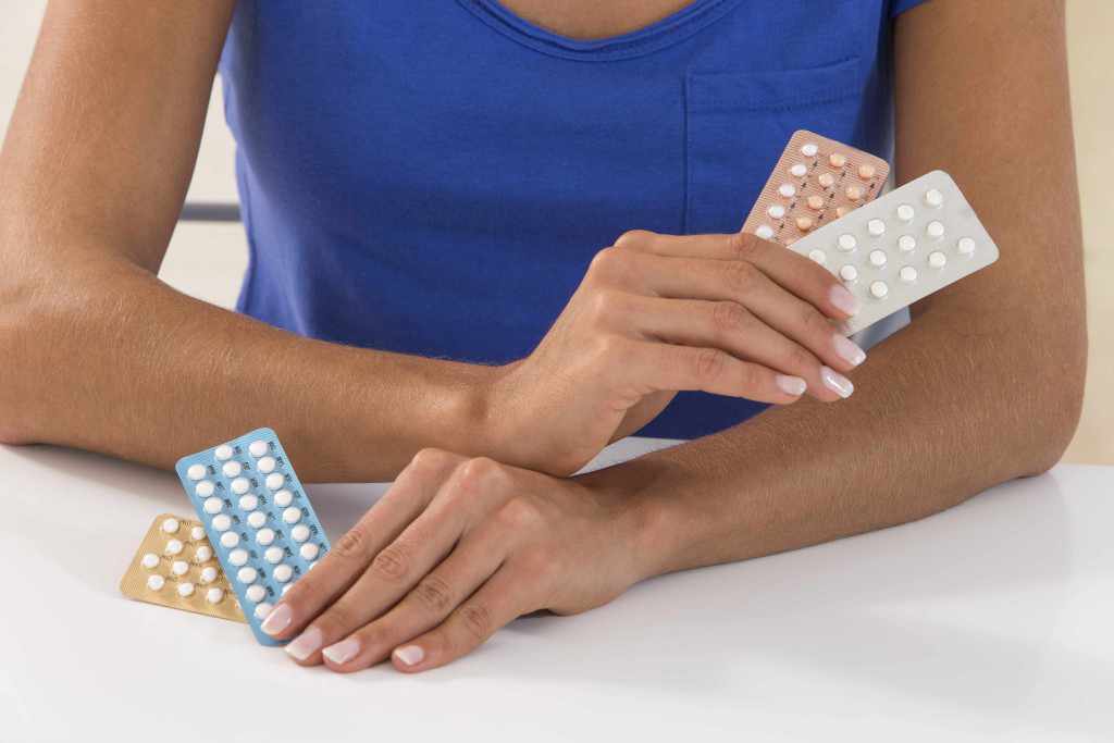 woman holding birth control contraceptive pills