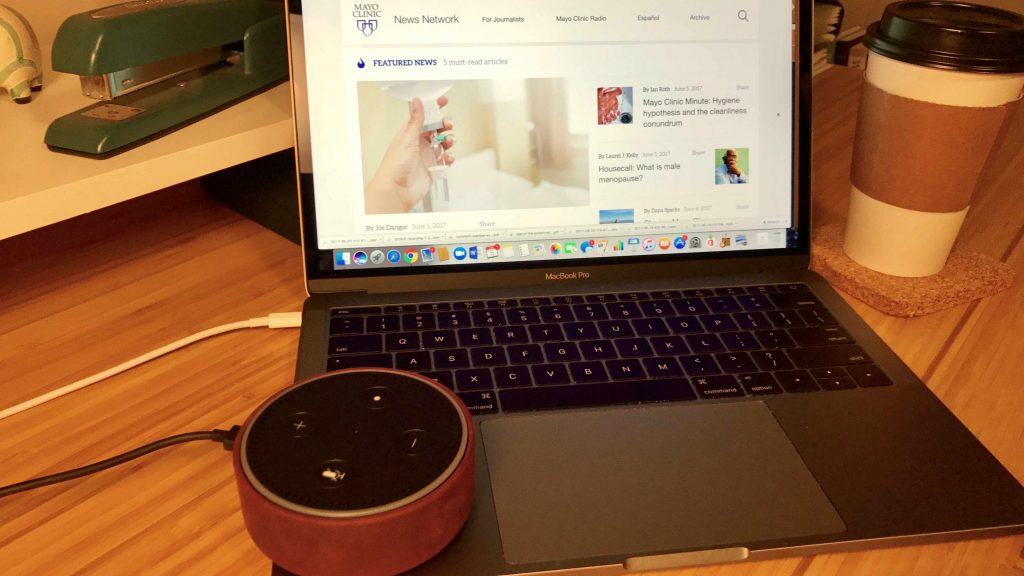 An Amazon Echo Dot rests on a laptop computer displaying an image of the Mayo Clinic News Network