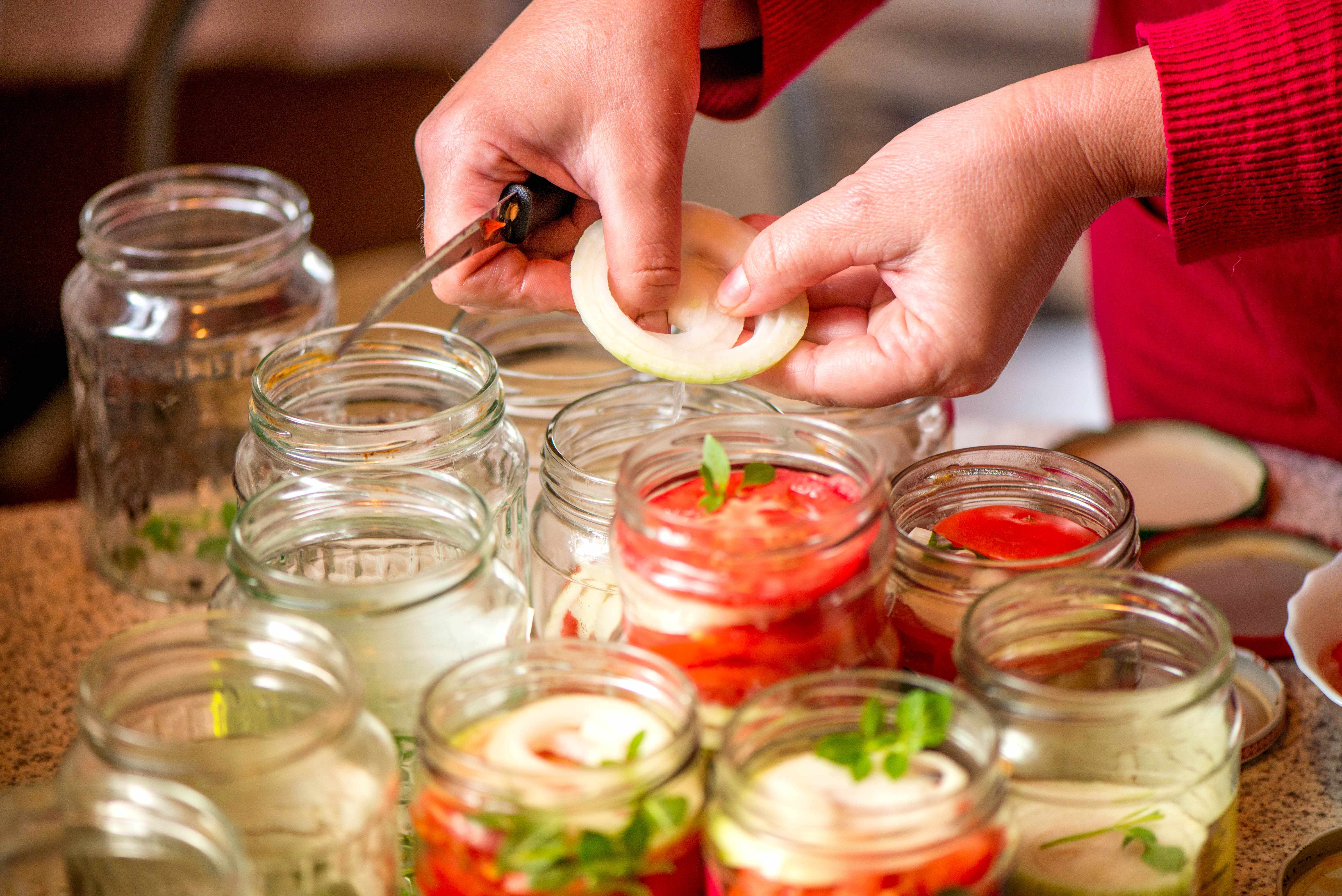 a person canning vegetables in jars