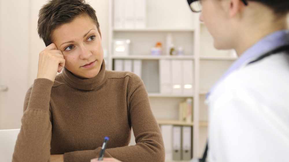 Doctora y paciente femenina preocupada en el consultorio durante la consulta