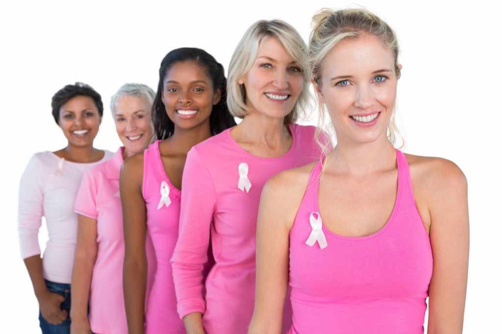 a line of women wearing pink shirts representing breast cancer awareness