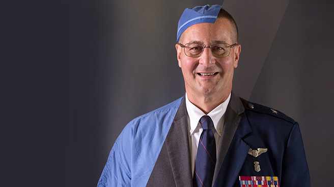 Dr. Michael Yaszemski in medical scrubs and military uniform