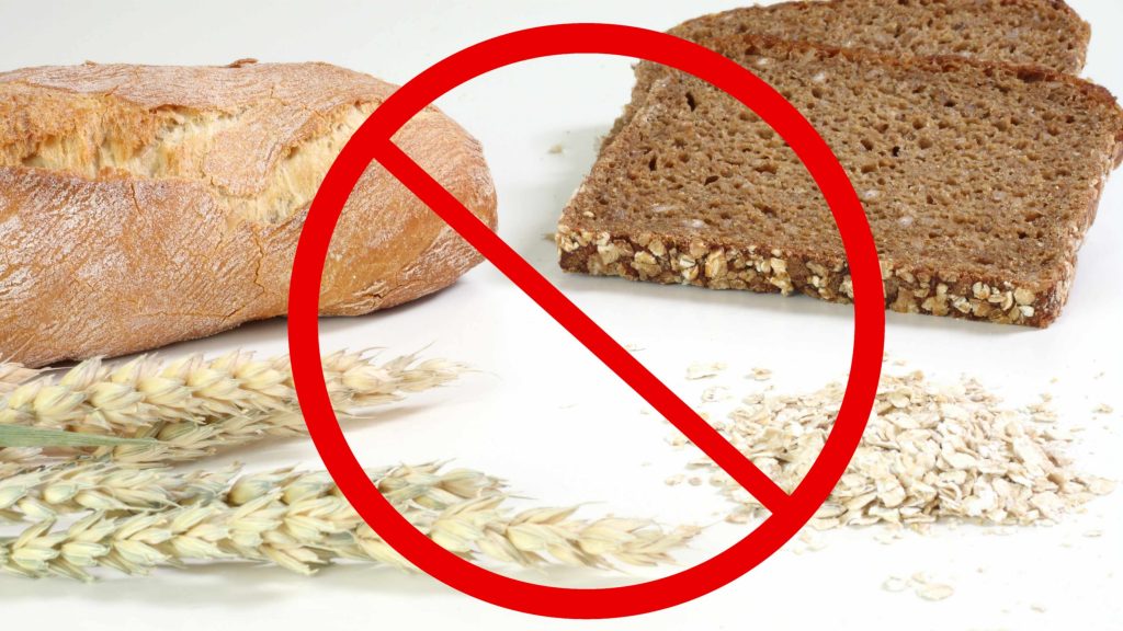El símbolo de “no” sobrepuesto a un grupo de granos de trigo, cereales y pan