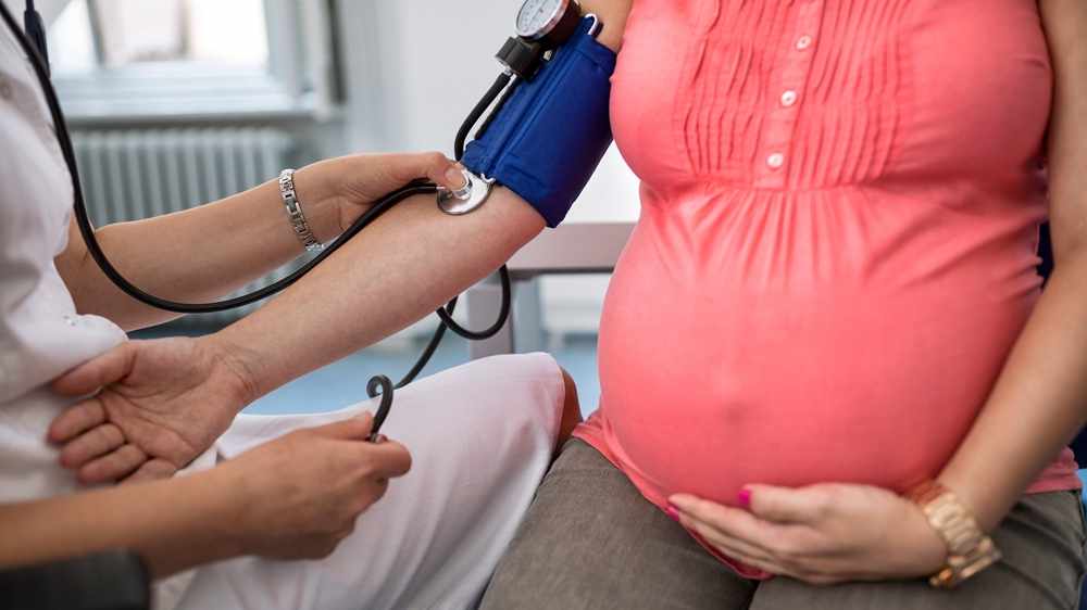 Mujer embarazada a quien se le mide la presión arterial