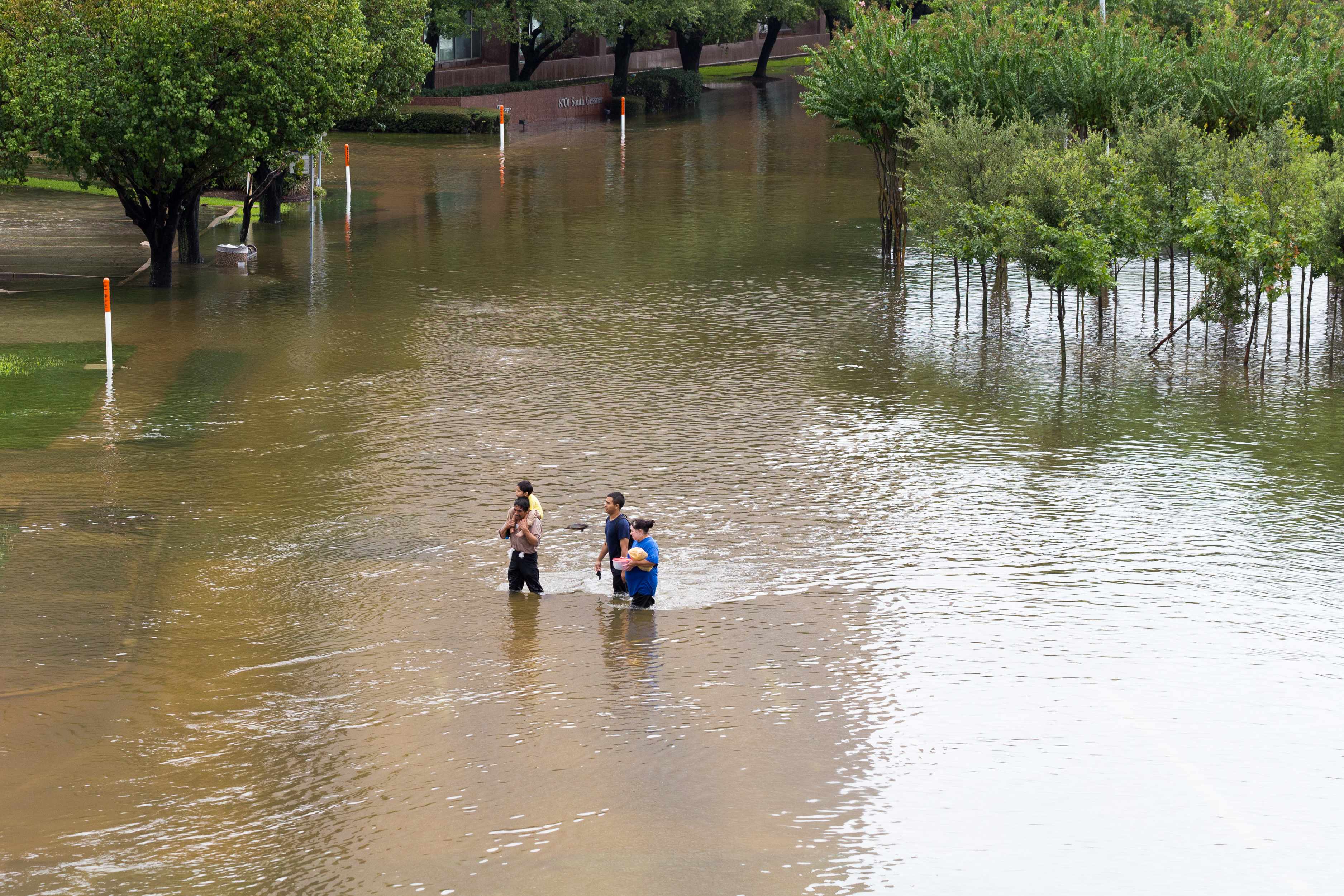 people walking through floodwaters in Houston after Hurricane Harvey